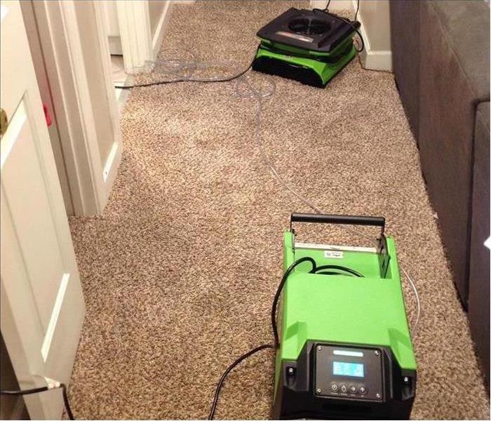 Two air movers on a wet carpet floor